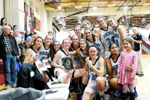 The girls basketball team poses with their regional championship plaque. They will face the Eleanor Roosevelt Raiders Thursday at Towson University in the state semifinals. Photo by Tyler Jacobson.
