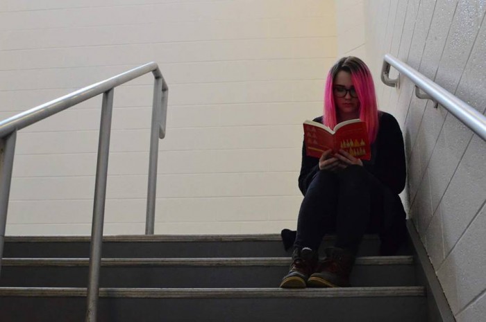 Finely reads her mindfulness book on the stairwell. Mindfulness has helped Finelli learn more about herself, she said. Photo by Tomas Castro.